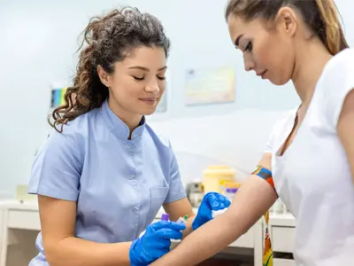 female health worker getting ready to draw blood from female patient